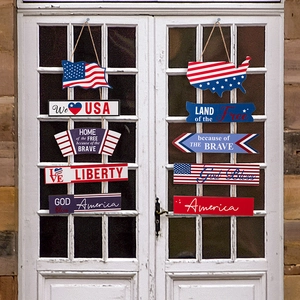 Detail of wooden Fourth of July hanging signs with USA motifs on a white door