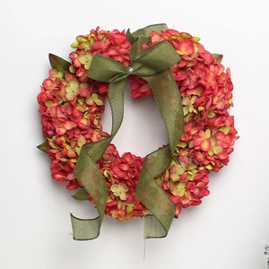 Detail of faux pink hydrangea wreath with a rustic green burlap bow on top