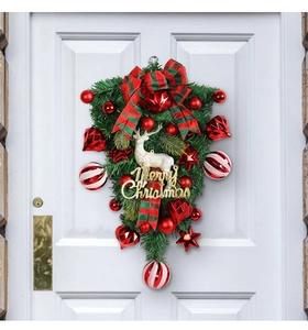 Christmas teardrop wreath with a white reindeer and Merry Christmas sign on a white door