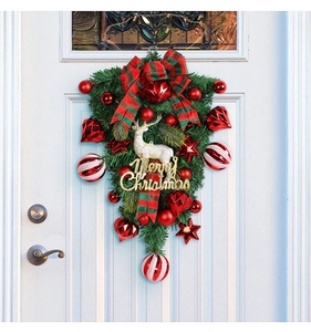 Detail of Christmas swag with reindeer, Merry Christmas sign, and red ribbon on door