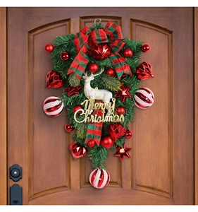 Detail of Christmas swag with reindeer, red baubles and Merry Christmas sign on wood door