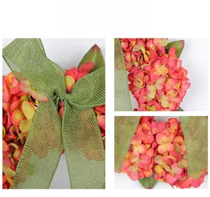 Detail of coral pink hydrangea wreath with rustic burlap mesh ribbon for home wall decor