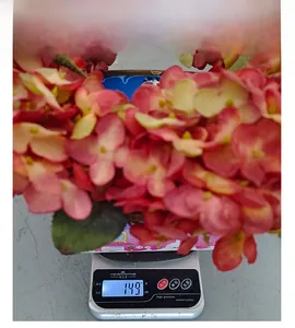 Detail shot of a pink autumn wreath being weighed on a digital scale showing 149g