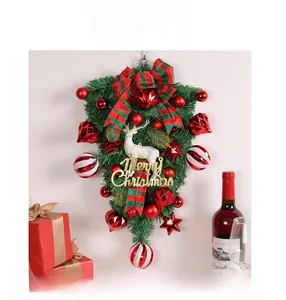 Detail of Christmas wreath with white reindeer, red baubles, and Merry Christmas sign