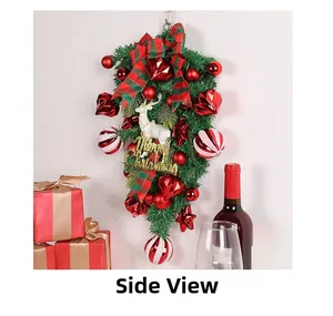 Side view of Christmas pine swag with red berries, plaid bows, and a reindeer ornament