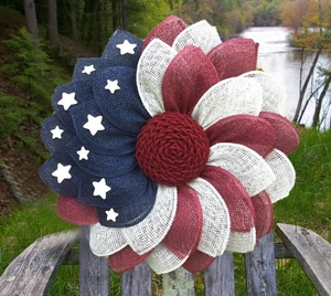 Detailopname van een handgemaakte jute krans met Amerikaanse vlag op een rustieke houten bank