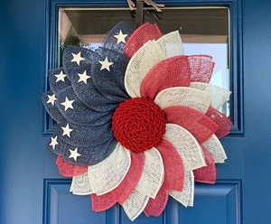 Macro detail of patriotic burlap sunflower wreath hanging on a blue wooden door