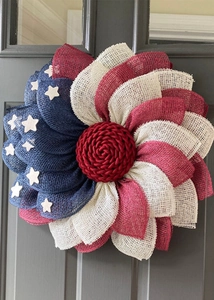 Detailed close-up of handmade red white blue patriotic star wreath on a dark wood door
