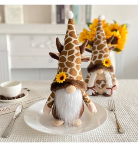 Dettaglio di gnomi di peluche con stampa giraffa e girasoli in ambiente accogliente