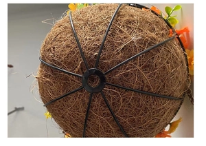 Detailaufnahme der Eisenampel mit Kokoseinlage und orangefarbenen Blumenelementen