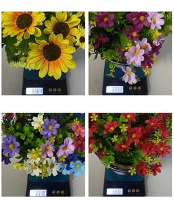 Künstliche Blumenampel mit Sonnenblumen auf einer Digitalwaage zeigt 336g Gewicht