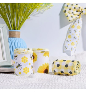 Detailaufnahme von Deko-Bändern mit Bienen und Sonnenblumen sowie feiner Kettelung