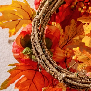 Close-up of autumn wreath featuring maple leaves and berries on a natural rattan base
