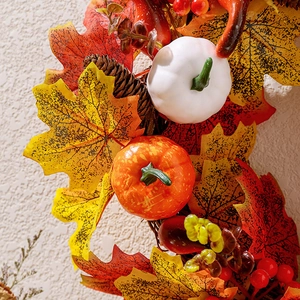 Autumn wreath featuring white pumpkins, maple leaves, and pine cones for fall home decor
