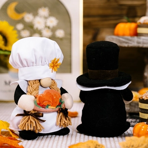 Detailed view of handmade harvest festival gnome pair with chef hat and sunflower decor