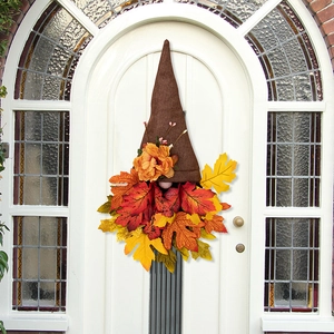 Close-up of autumn gnome door wreath with burlap hat and vibrant maple leaves decor