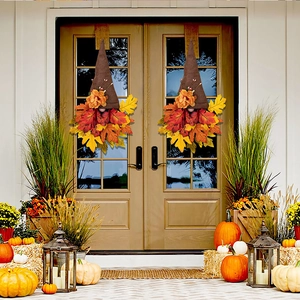 Detail of harvest gnomes with maple leaf beards hanging on a white wooden front door