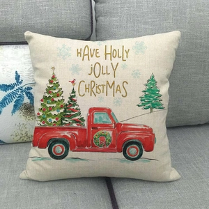 Detalle de funda de cojín de lino con estampado de camión rojo navideño en sofá