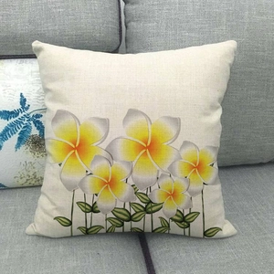 Dettaglio della trama della federa in lino con stampa floreale plumeria gialla su divano