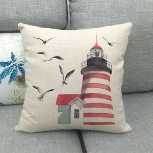 Close-up of linen pillowcase with lighthouse and seagulls print on a grey sofa