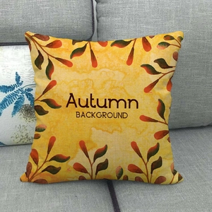 Autumn watercolor linen pillow cover with yellow fall leaves on a grey sofa