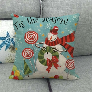 Close-up of linen Christmas pillow cover with snowman design on a gray sofa