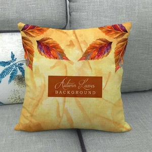 Detail of linen autumn pillowcase with watercolor maple leaves on a grey sofa