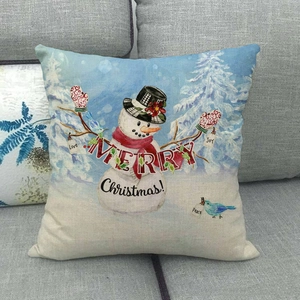 Close-up of linen Christmas pillowcase with snowman design on a grey fabric sofa