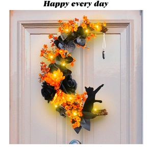 Detail of moon-shaped Halloween wreath with black cat silhouette and warm LED lights