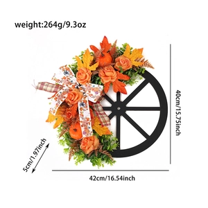 Detail of wooden wheel wreath with autumn pumpkins, maple leaves and orange roses