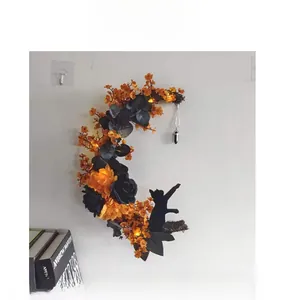 Detail of Halloween moon wreath with orange roses, black cat silhouette and LED lights