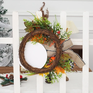 Fall pumpkin wreath with sunflowers and burlap bow on white fence for Thanksgiving decor