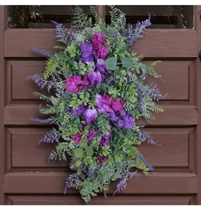 Close-up of artificial purple tulip swag with eucalyptus leaves on a vintage wood door