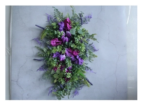 Close-up of lavender wreath with eucalyptus leaves on a textured grey background