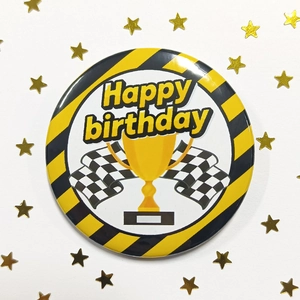 Détail du badge en fer-blanc 58mm avec motif de course et trophée Happy Birthday