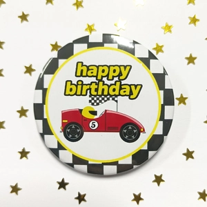 Détail du badge en fer-blanc de 58 mm avec voiture de course rouge et joyeux anniversaire