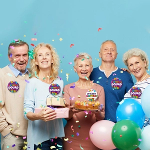 Macro shot of 58mm tinplate birthday badges on shirts at a cheerful party celebration