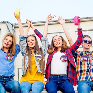 Outdoor shot of teenagers wearing purple and white It's My Birthday and Squad tinplate badges