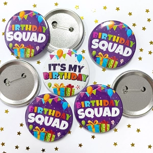 Detail view of tinplate birthday badges with metal safety pins and party patterns