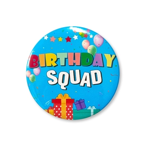 Close-up of a blue 58mm Birthday Squad tinplate badge with colorful party decorations