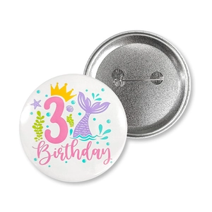 Detail showing the front design and metal pin back of the mermaid birthday badge