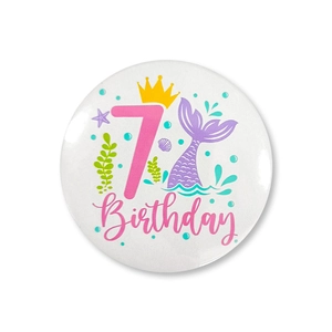 Close-up of number 7 mermaid birthday tinplate badge with ocean theme shell patterns
