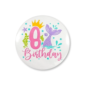 Detailed close-up of mermaid themed tinplate badge featuring crown and number 8 for party