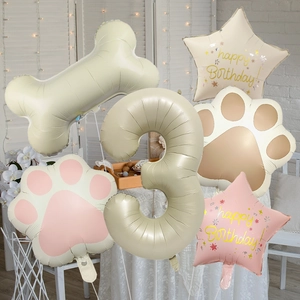 Close-up of dog bone foil balloons and paw print set for 3rd birthday party decor