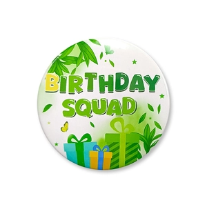 Detail of a round tinplate badge featuring Birthday Squad text and green leaf patterns