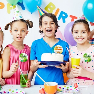 Kids wearing Birthday Squad and It's My Birthday badges at a festive party scene