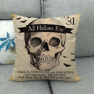 Halloween kussenhoes met schedel en vintage krantenprint op een grijze bank