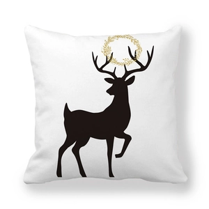 Detail of soft peach skin pillow cover featuring a black reindeer with golden floral wreath