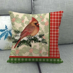 Linen Christmas pillow case featuring a red cardinal bird on a gray fabric sofa