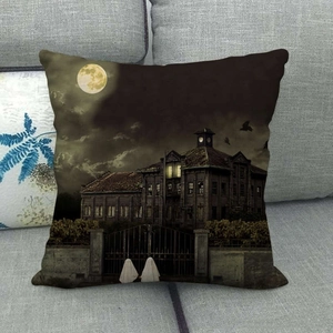 Detail of linen Halloween pillowcase with dark gothic house and full moon on a sofa